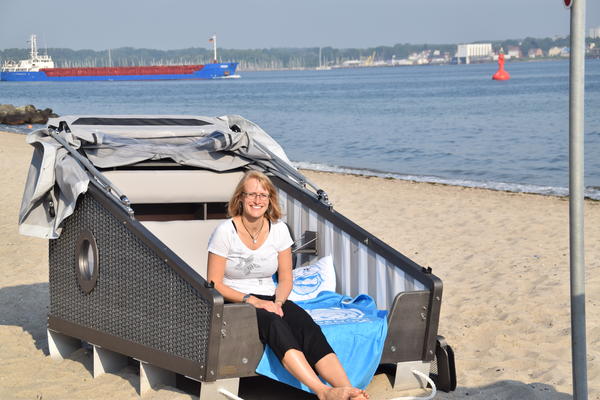 Bild vergr&ouml;&szlig;ern: &Uuml;bernachten unter freiem Himmel an der Kieler F&ouml;rde: Jana K&auml;rcher von Kiel-Marketing beim Probeliegen im Schlaf-Strandkorb am Heikendorfer Strand.  im