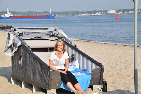 Übernachten unter freiem Himmel an der Kieler Förde: Jana Kärcher von Kiel-Marketing beim Probeliegen im Schlaf-Strandkorb am Heikendorfer Strand.  im 