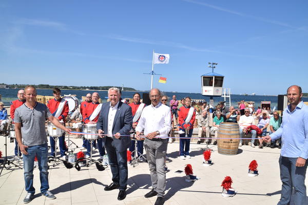 Bild vergr&ouml;&szlig;ern: Mit einem symbolischen Scherenschnitt gaben Bürgermeister Tade Peetz (Zweiter von links) und sein Amtsvorgänger Alexander Orth die neue Heikendorfer Uferweg-Promenade im Sommer 2018 frei. Rechts Planer Dirk Barteldt, l. Roman Vietzent von der Fa. Schnoor.