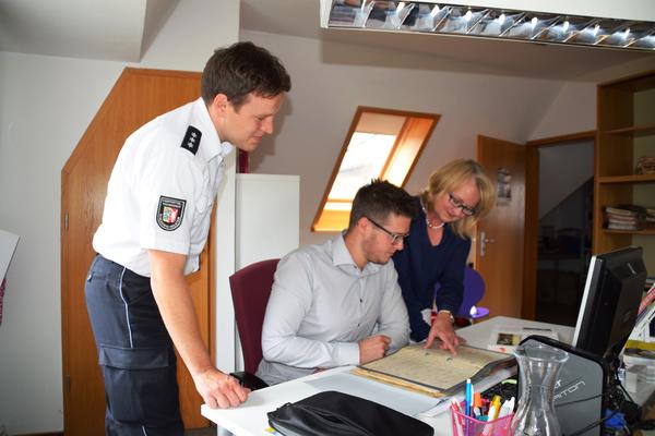 Bild vergr&ouml;&szlig;ern: Mark Wernicke, Marten Thiele und Brigitte Hatke-Beck (v.l.) bei der Auswertung der Bombenaufzeichnungen im Schrevenborner Amtsarchiv in Mönkeberg.