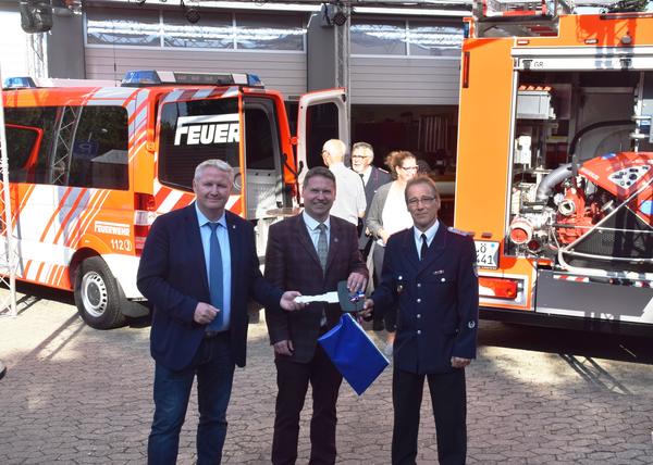 Bild vergr&ouml;&szlig;ern: Symbolische Schlüsselübergabe für gleich zwei Feuerwehrfahrzeuge: Bürgermeister Tade Peetz (v.l.), Kreispräsident Stefan Leyk und Neuheikendorfs Ortswehrführer Oliver Greve.