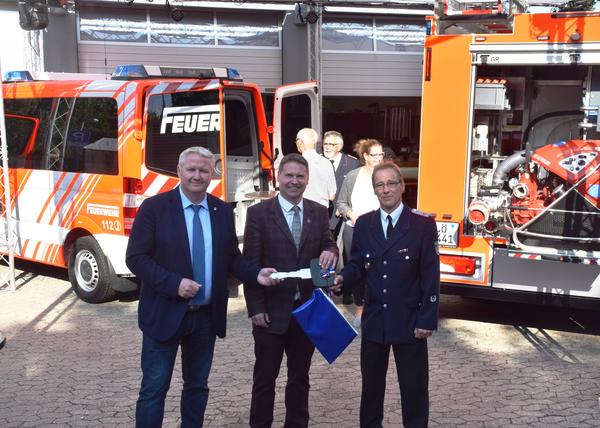 Symbolische Schlüsselübergabe für gleich zwei Feuerwehrfahrzeuge: Bürgermeister Tade Peetz (v.l.), Kreispräsident Stefan Leyk und Neuheikendorfs Ortswehrführer Oliver Greve. 