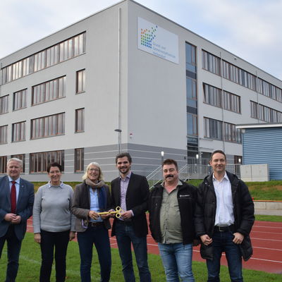 Bild vergr&ouml;&szlig;ern: Bürgermeister Tade Peetz, stellvertr. Schulleiterin Kirsten Kiehn, Schulleiterin Brigitte Peschties, Damian Grzonka und Olaf Frase (Fa. Goldbeck) sowie Mirco Schablack (Amtsverwaltung) vor dem Schulneubau.