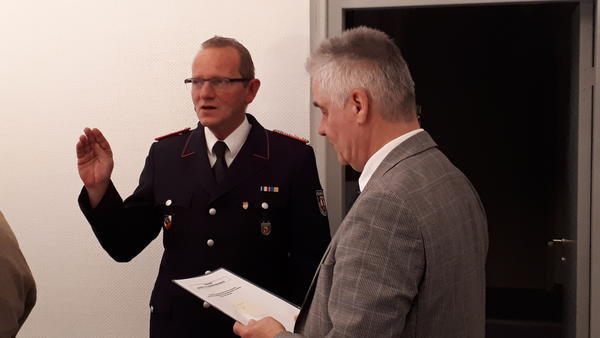 Bild vergr&ouml;&szlig;ern: Wiedergewählt: Schönkirchens Ortswehrführer Mario Mordhorst wird von Bürgermeister Gerd Radisch hier für weitere sechs Jahre vereidigt.