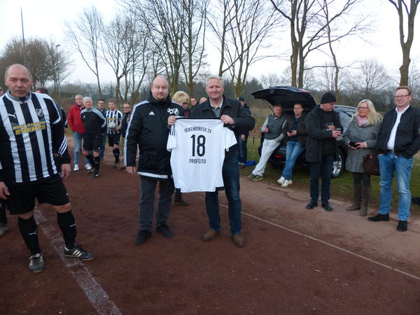 Michael Voß von der Fußballabteilung des Heikendorfer SV überreicht Bürgermeister Tade Peetz hier ein HSV-Trikot mit der Spielernummer 18. Links im Bild der spätere Torschütze Helge Schöpke. 