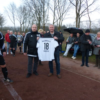 Michael Voß von der Fußballabteilung des Heikendorfer SV überreicht Bürgermeister Tade Peetz hier ein HSV-Trikot mit der Spielernummer 18. Links im Bild der spätere Torschütze Helge Schöpke. 