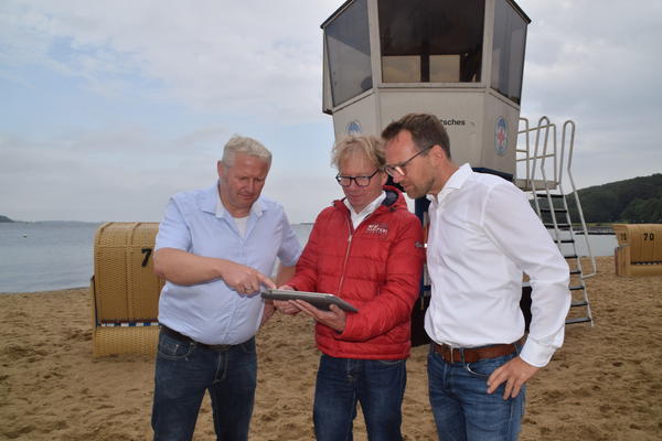 Stabiles WLAN-Signal: Bürgermeister Tade Peetz (von links) , Niels Tönder von der IT-Abteilung des Amtes und FDP-Gemeindevertreter Gunnar Schulz am Strand von Möltenort. 