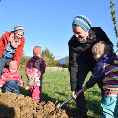 Familie Ebeling bei ihrer Baumpflanzung mit Tochter Ylva als Baumpatin und Greta an der Pflanzschaufel.  