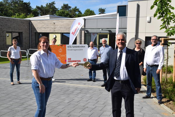 Bild vergr&ouml;&szlig;ern: Schlüsselübergabe: Bürgermeister Gerd Radisch und Kita-Leiterin Corinna Freisenhaus. Im Hintergrund v.l. Eva Hegge-Goldschmidt, Christian Pagel und Jörg Poser (JUH), Bürgervorsteher Ernst-P. Schütt, Architektin Annkatrin Grohman, Udo Neumann (JUH).