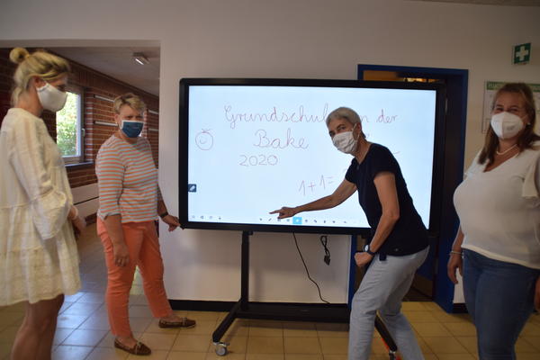 Bild vergr&ouml;&szlig;ern: Schulleiterin Kirsten Sandberg (Zweite von links), hier zusammen mit ihren Kolleginnen (v.l.)  Inke Specht, Brigitte Voesch und Janina Groß beim Testen der Whiteboard-Funktion an einer der neuen digitalen Tafel.