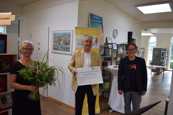 Bild vergr&ouml;&szlig;ern: "Qualifizierte Bibliothek zwischen den Meeren": Büchereileiterin Eva Irion, Bürgermeister Gerd Radisch und Oke Simons vom Büchereiverein bei der Zertifikat-Übergabe.