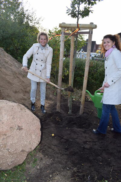 Bürgermeisterin Hilla Mersmann und Amtsdirektorin Juliane Bohrer bei der Baumpflanzung. 