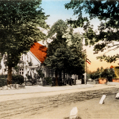 Die Dorfstraße am Dorfteich mit der Gastwirtschaft »Im Landhause« mit dem »Utspann« als colorierte Postkarte von 1930. Im Hintergrund das Gehöft von Rußmann. Rechts am Bildrand die »Friedenseiche«, die nach dem Krieg gegen Frankreich 1871 gepflanzt wurde.