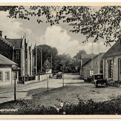 Die Alte Schule 1943 und die links an der Dorfstraße gebauten ersten beiden zweistöckigen Häuser von 1911 wurden zu einem Postkartenmotiv aus Schönkirchen.
