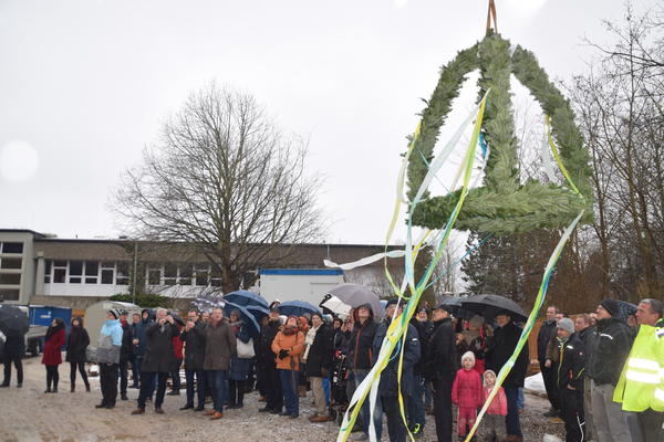 Bild vergr&ouml;&szlig;ern: Richtfest Schulneubau:Bei winterlichem Schmuddelwetter wurde der Richtkranz per Kran in die Höhe befördert.
