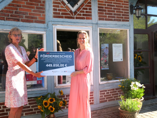 Landwirtschaftsministerin Cornelia Schmachtenberg (rechts) und Heikendorfs stellvertretende Bürgermeisterin Angela Kahrs mit dem symbolischen Förderbescheid für das Rudolf-Behrend-Haus. 